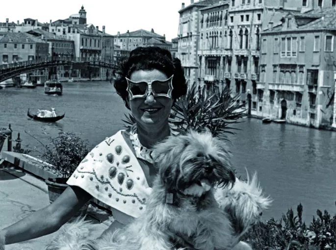Peggy Guggenheim prend un bain de soleil sur la terrasse de son «&nbsp;Palazzo&nbsp;» à Venise en 1950 arborant ses lunettes «&nbsp;chauve-souris&nbsp;» créées par Edward McCarth.